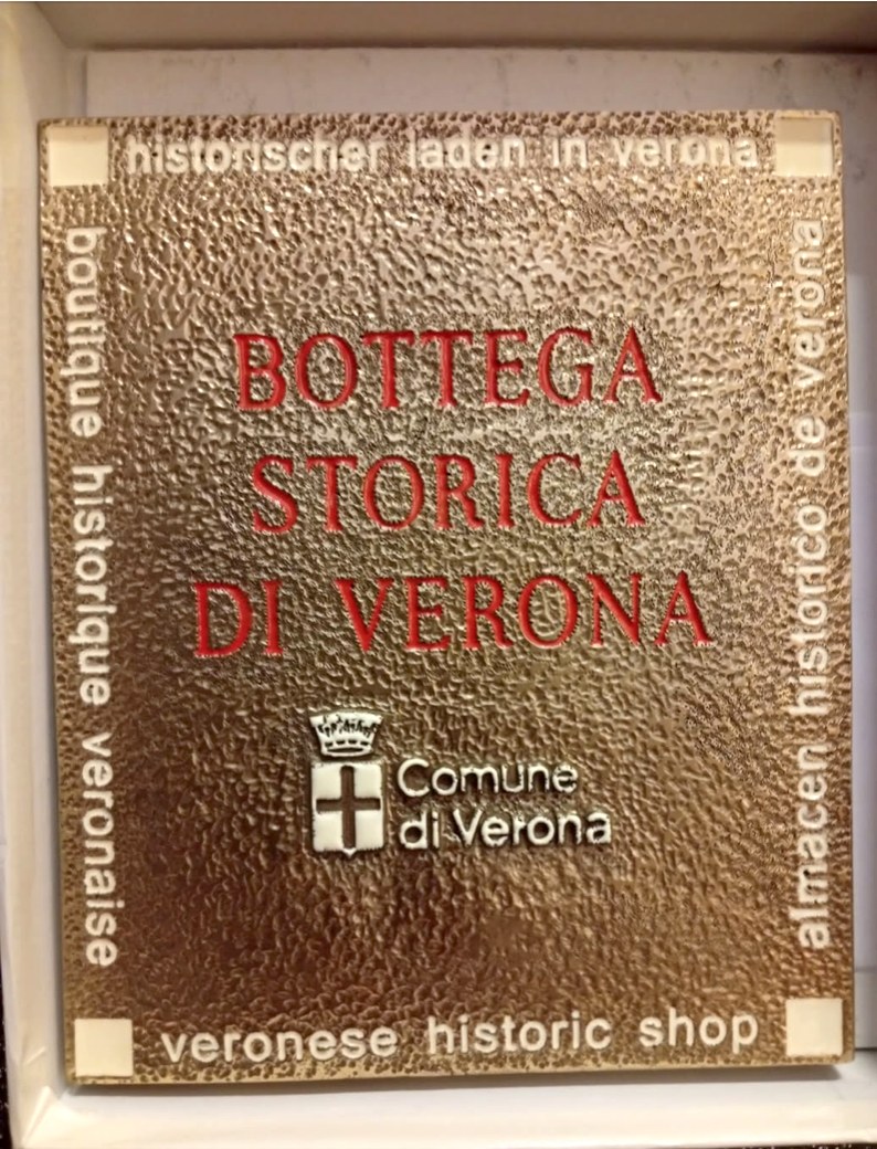 Facciata della bottega storica Dolci Idee a Verona con targa gialla